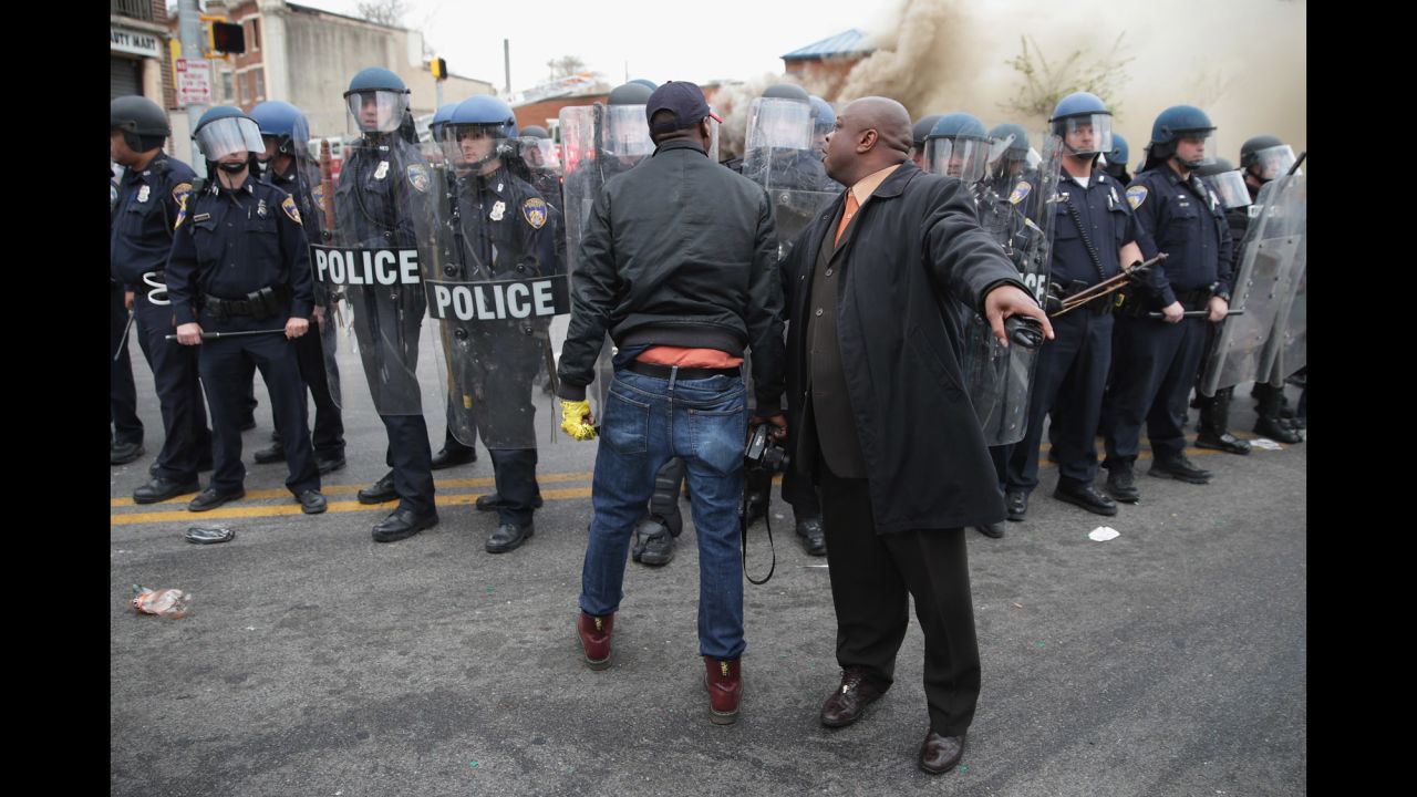 A man attempts to calm a fellow demonstrator as they face police in Baltimore in April 2015. Riots broke out after <a href="http://www.cnn.com/2015/04/27/us/gallery/freddie-gray-funeral/index.html">the funeral for Freddie Gray</a>, who died of a severe spinal cord injury while in police custody. His death sparked <a href="http://www.cnn.com/2015/04/23/us/gallery/freddie-gray-protest/index.html">protests in Baltimore</a> and raised long-simmering tensions between police and residents.