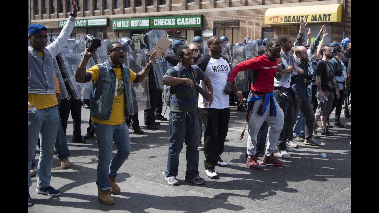Demonstrators stand in front of a police line and call for peace after a bottle was thrown on April 28.