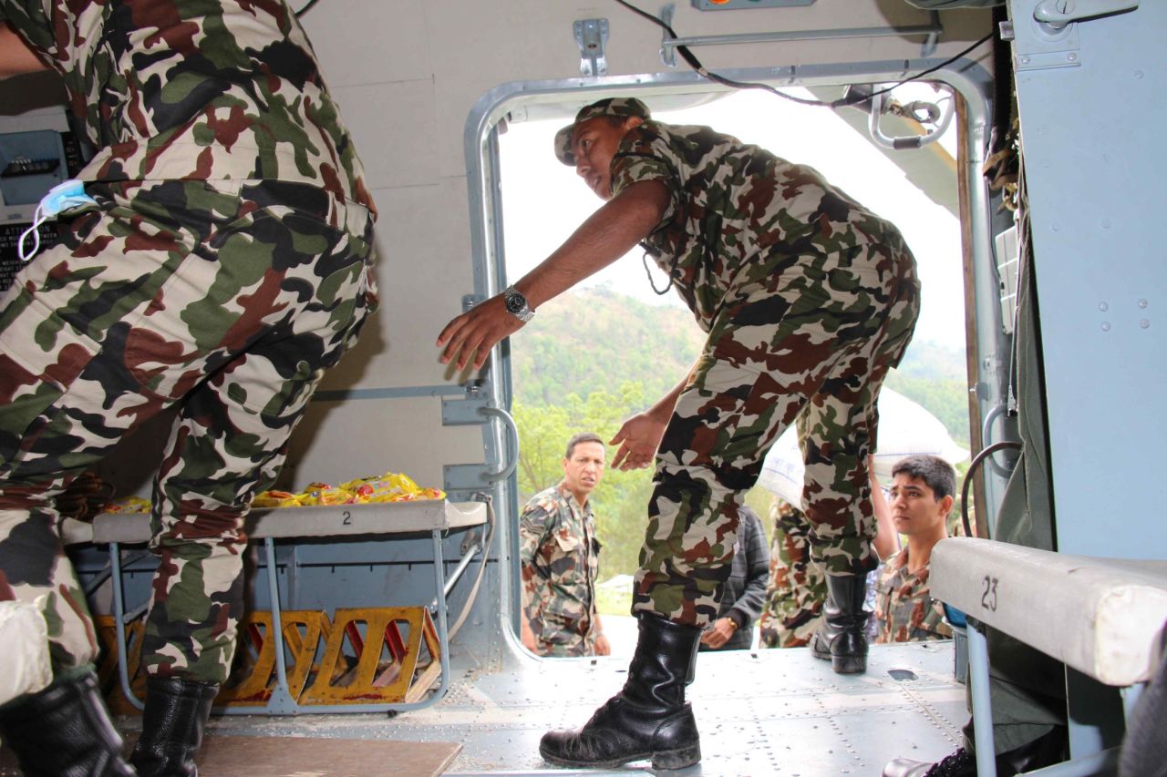 Nepalese soldiers offload much needed aid supplies, including packages of rice, noodles and tuna, medicine and tents once they land in Melamchi.