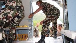 Nepalese soldiers offload packs of rice, noodles and tuna, medicine and tents in Melamchi.