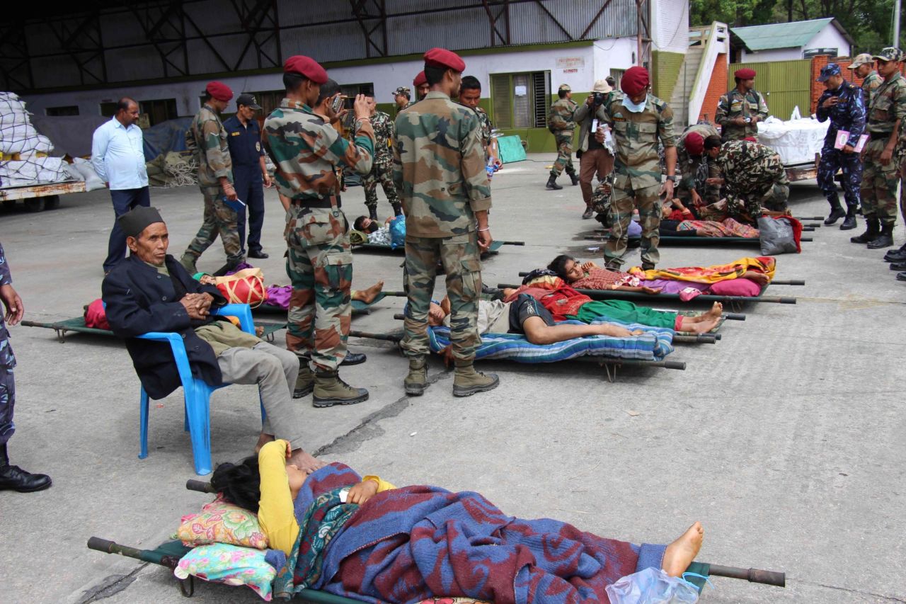 Injured earthquake victims are laid out on stretchers at an emergency army triage center at the air base in Kathmandu.