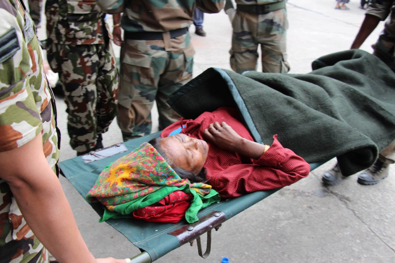 Forshani Tamang, whose children carried her for four hours from her village, Bachunde, to Malamchi for help, is picked up at the Kathmandu air base to be taken to hospital. 