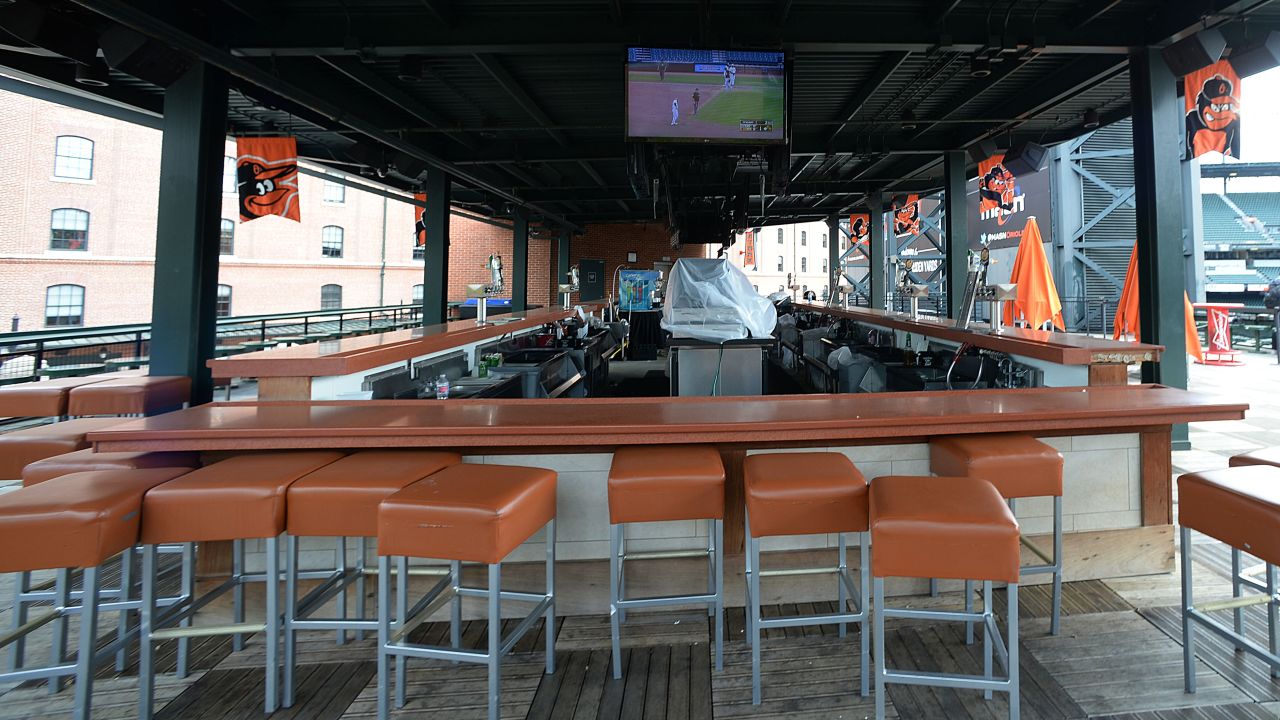 A bar showing the baseball game sits empty behind center field. 