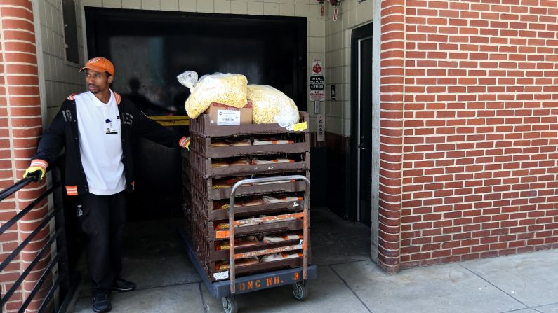 A vendor waits for an elevator after removing food from concessions.