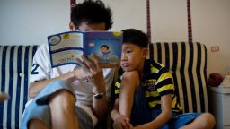 To go with China-education-society, FEATURE by Tom Hancock
In a photo taken on July 31, 2012 eight-year-old Zhang Hongwu reads with his father Zhang Qiaofeng during his home schooling at their apartment in Beijing. Giving up his successful career as the head of a medical research firm to spend his days at home reading from children's story books was a tough choice for Chinese father Zhang Qiaofeng.    AFP PHOTO / Ed Jones        (Photo credit should read Ed Jones/AFP/GettyImages)
