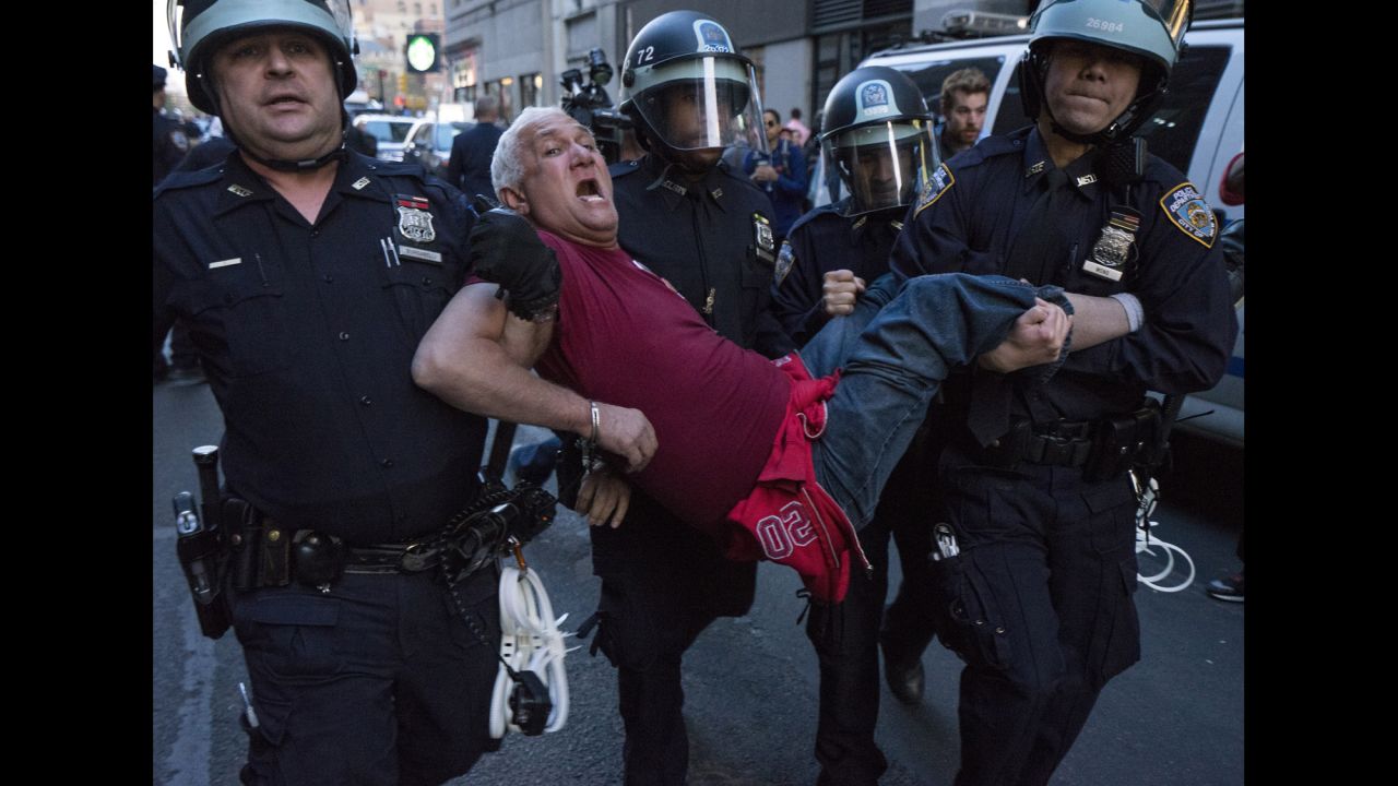 Police officers carry a man away in Union Square in New York on April 29. More than 100 people were arrested during demonstrations, New York police said.