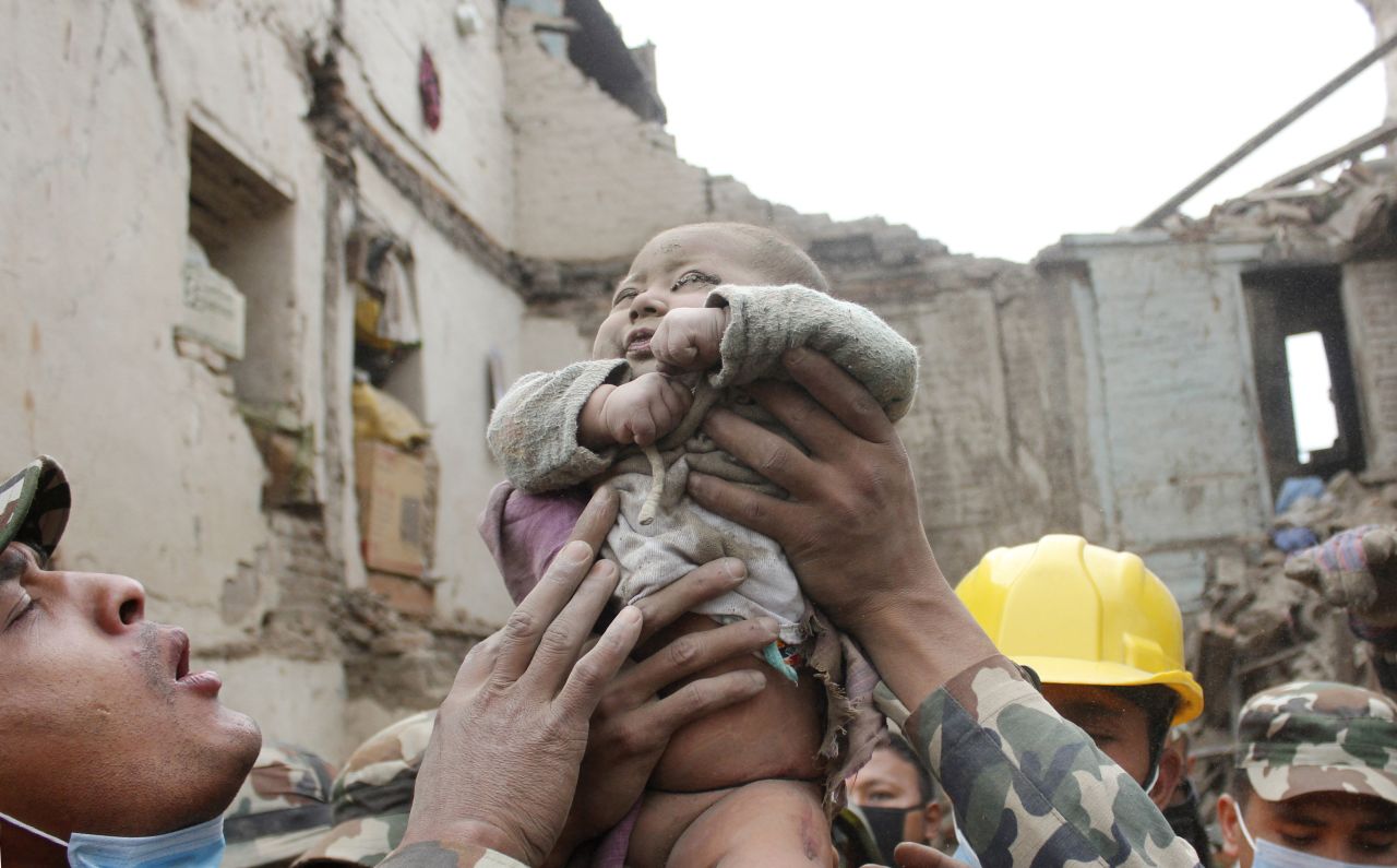 Four-month-old Sonit Awal is held up by Nepalese army soldiers after being rescued from the rubble of his house in Bhaktapur, Nepal, on April 26.
