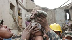 In this Sunday, April 26, 2015, photo taken by Amul Thapa and provided by KathmanduToday.com, four-month-old baby boy Sonit Awal is held up by Nepalese Army soldiers after being rescued from the rubble of his house in Bhaktapur, Nepal, after Saturday's 7.8-magnitude earthquake shook the densely populated Kathmandu valley.  Thapa says that when he saw the baby alive after 20 hours of rescue efforts "... all my sorrow went. Everyone was clapping. It gave me energy and made me smile in spite of lots of pain hidden inside me." (Amul Thapa/KathmanduToday.com via AP)