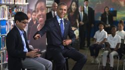 U.S. President Barack Obama (R), with student moderator Osman Yaya (L), responds to a question during a 'Virtual Field Trip' with middle school students from around the country at Anacostia Library April 30, 2015 in Washington, DC. Students countrywide participated to discuss efforts to increase learning opportunities with improving access to digital reading content and public libraries.