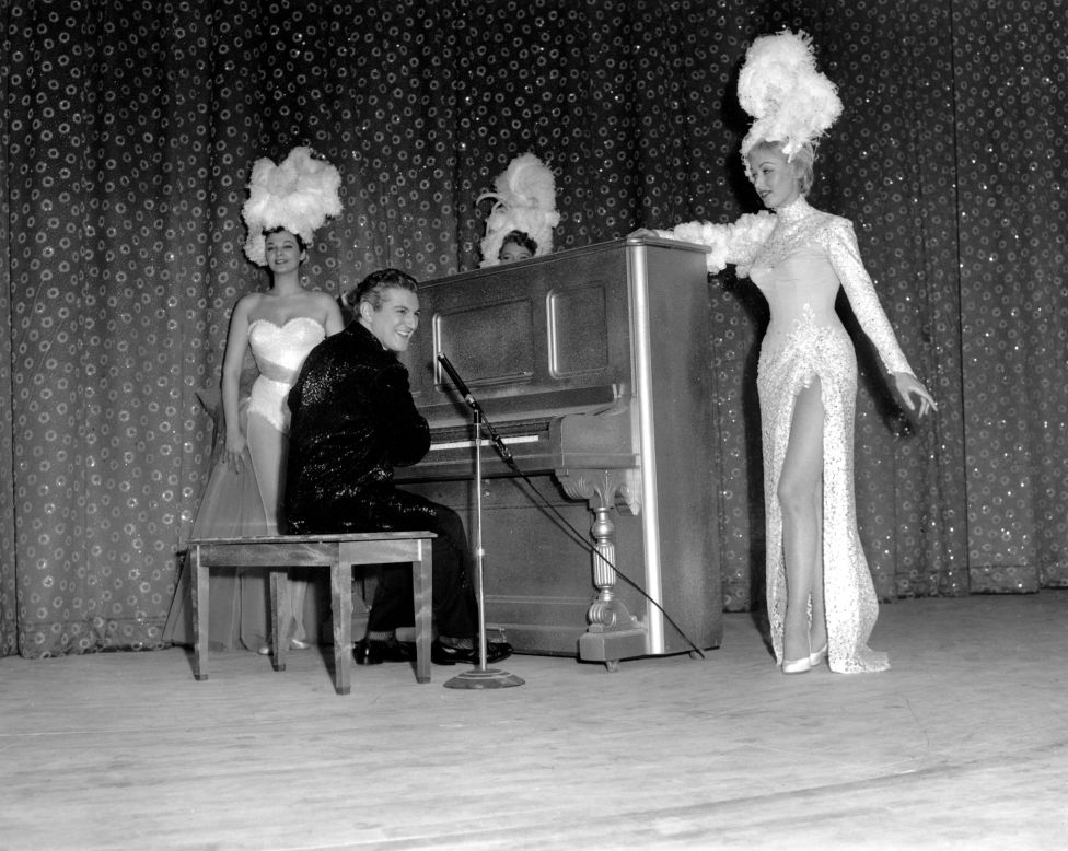 Liberace's "Piano Roll Blues" helped roll out the carpet at the premiere of the Riviera in April 1955. Here, Liberace is shown in attire by Dior and with support from hotel chorus girls.