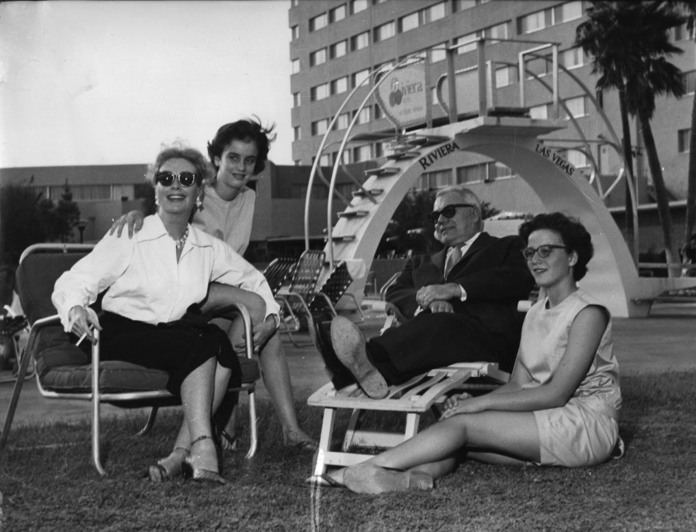Actress Joan Crawford relaxes with her husband, Alfred Steele, and her twin daughters, Cathy and Cindy, at the Riviera's pool in October 1958.