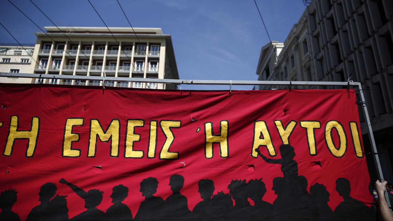 Protesters hold up a banner during a May Day rally in Athens, Greece.