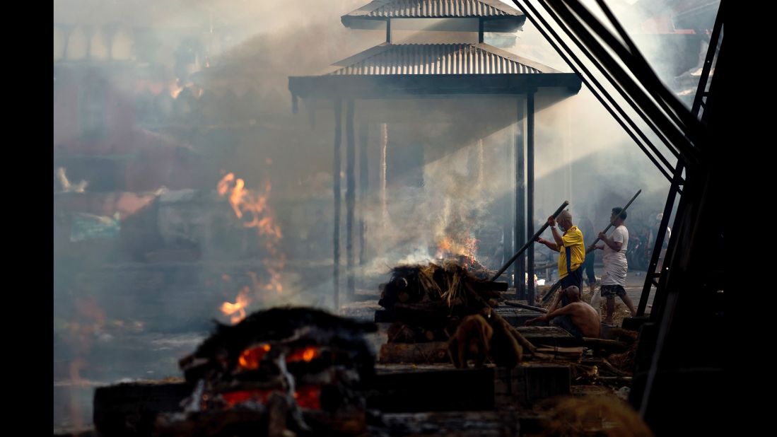 Hindu priests perform rituals during the cremations of victims at the Pashupatinath Temple on the banks of the Bagmati River in Kathmandu on May 1.