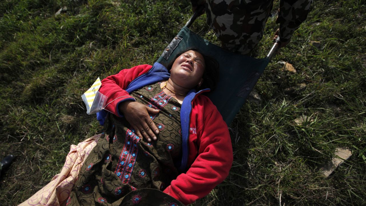 An injured woman gets carried on a stretcher at Kathmandu's airport after being evacuated from Melamchi, Nepal, on May 1.