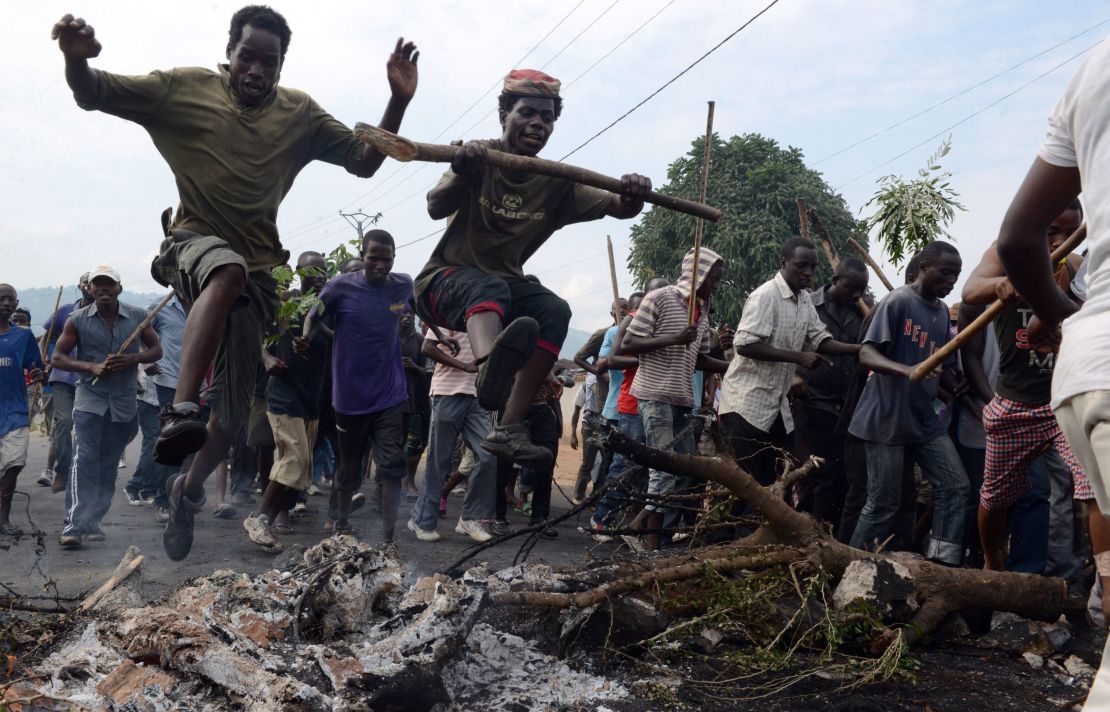 Young Burundians jump over a burning barricade as they demonstrate Friday in Bujumbura,  against the president's bid for a third term. 