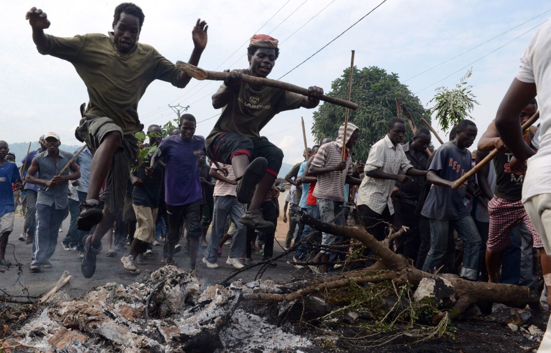 Young Burundians jump over a burning barricade as they demonstrate Friday in Bujumbura, against the president's bid for a third term.