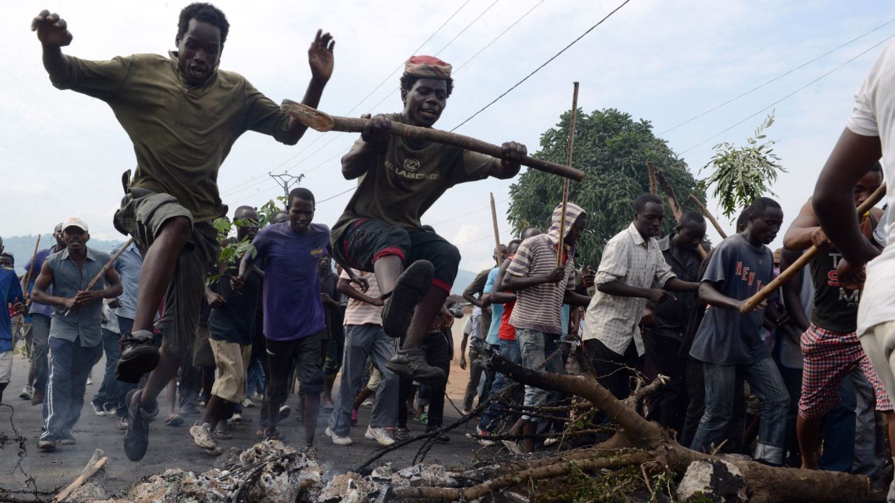 Young Burundians jump over a burning barricade as they demonstrate Friday in Bujumbura,  against the president's bid for a third term. 