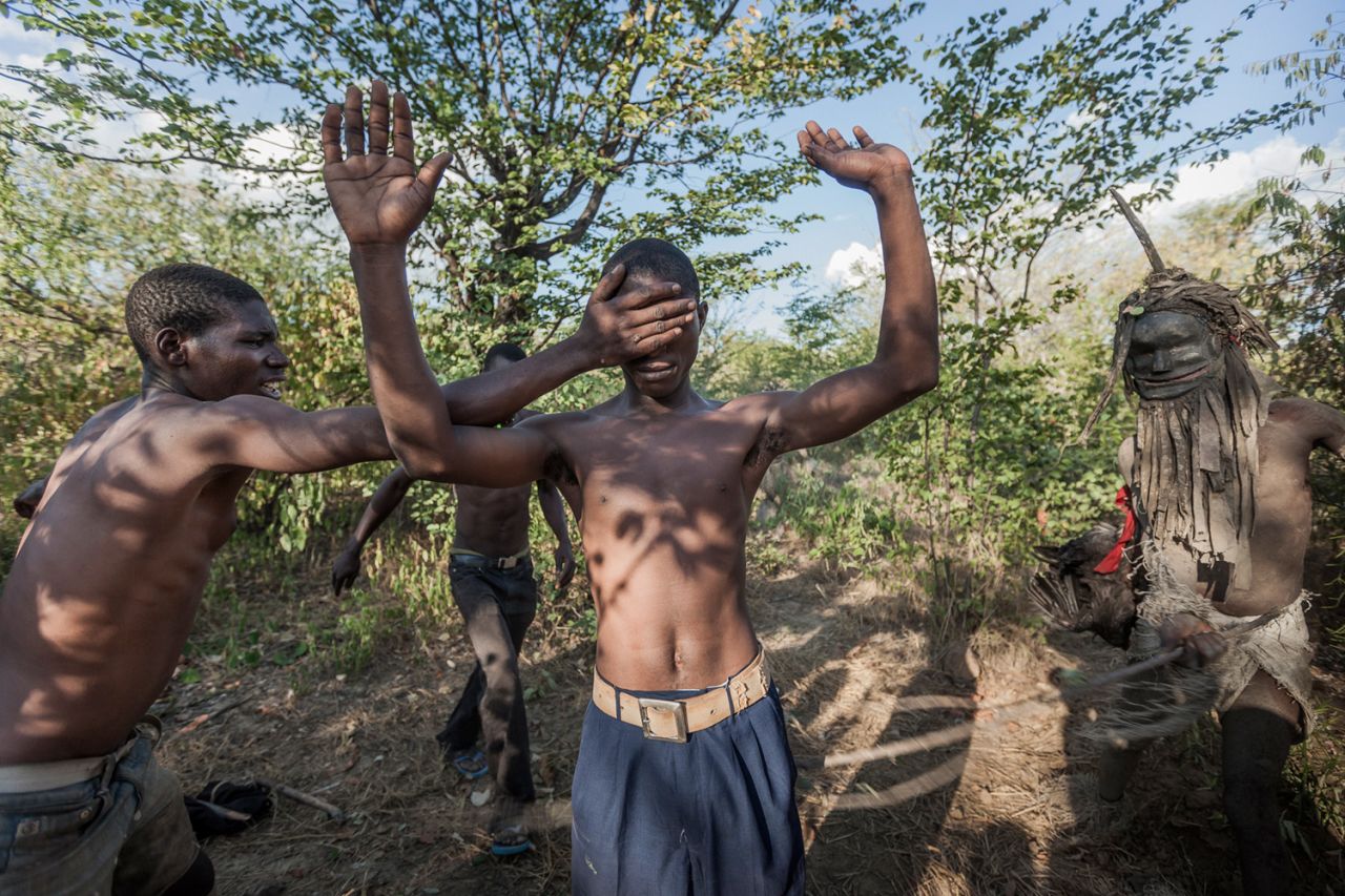 "This photograph is of the initiation. When I was initiated, they hit me a little bit with a stick -- hitting is an important part of the ceremony as it serves as a warning not to reveal the secrets of the Nyau. <br /><br />"They removed the fabric and started dancing and I danced with them. We danced the whole night, then they took me to their hidden place -- the cemetery. They told me, 'Now, you're Nyau.' They gave me my own mask and costume and started to teach me how to dance."