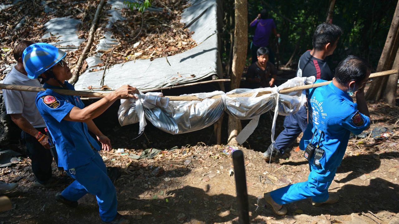 Rescue workers carry a body found at a grave in Thailand near the Malaysian border in May this year.