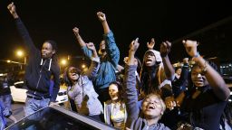 Demonstrators celebrate the announcement of six officers charged in the police-custody death of Freddie Gray before a curfew goes into effect on Friday, May 1, in Baltimore.