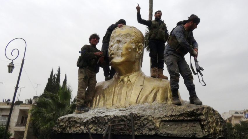 Fighters loyal to Al-Qaeda's Syrian affiliate and its allies smash a statue of late Syrian president Hafez al-Assad, father of current President Bashar al-Assad on March 28, 2015 in the northwestern Syrian city of Idlib.