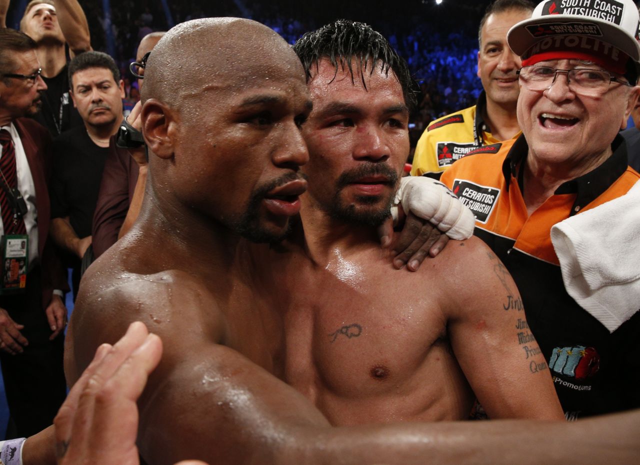 Mayweather left, hugs Pacquiao after defeating him in their welterweight unification bout.