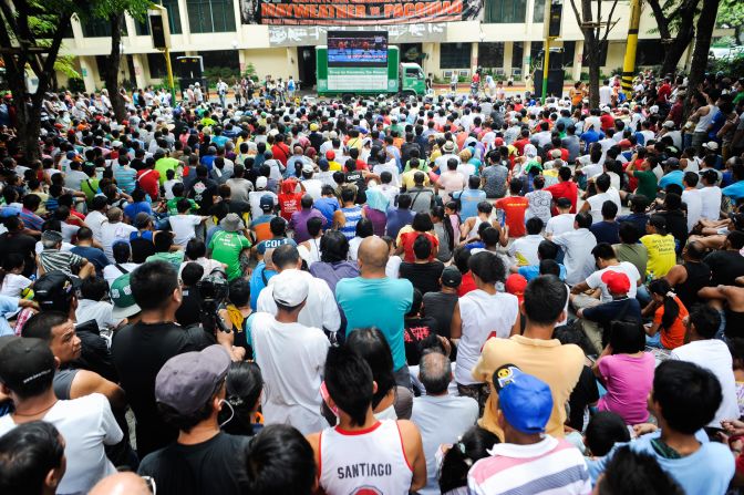 Filipinos consider Pacquiao a national hero. He is an elected member of the national Congress, the coach and player on his own professional basketball team, and a real-life rags-to-riches success story. Here people watch the bout at a public plaza in Marikina City, Philippines. 