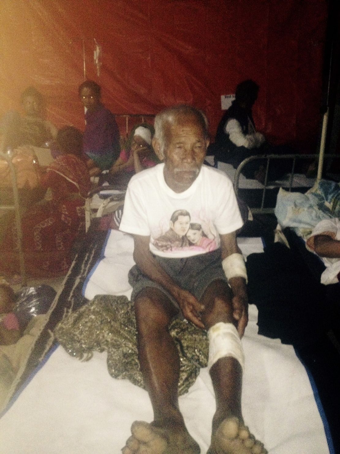 Funchu Tamang, 101, sits at a hospital in Nuwakot district on Sunday after being rescued from his collapsed home.