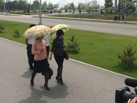 Pyongyang women wear their Sunday best -- and carry ornate umbrellas to shield themselves from the sun.