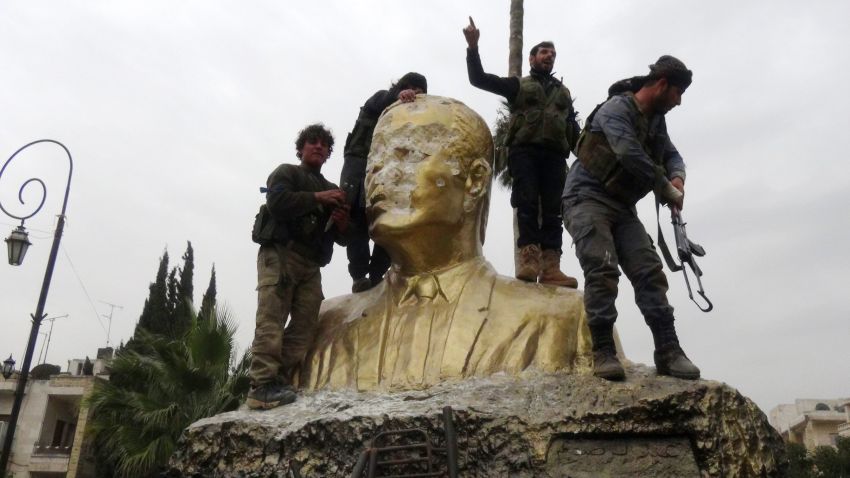 Fighters loyal to Al-Qaeda's Syrian affiliate and its allies smash a statue of late Syrian president Hafez al-Assad, father of current President Bashar al-Assad on March 28, 2015 in the northwestern Syrian city of Idlib . A coalition made up of Al-Nusra Front, the official Syrian affiliate of Al-Qaeda, and several Islamist factions seized the city of Idlib, only the second provincial capital to be lost by the regime in more than four years of war. AFP PHOTO / SAMI ALI (Photo credit should read Sami Ali/AFP/Getty Images)
