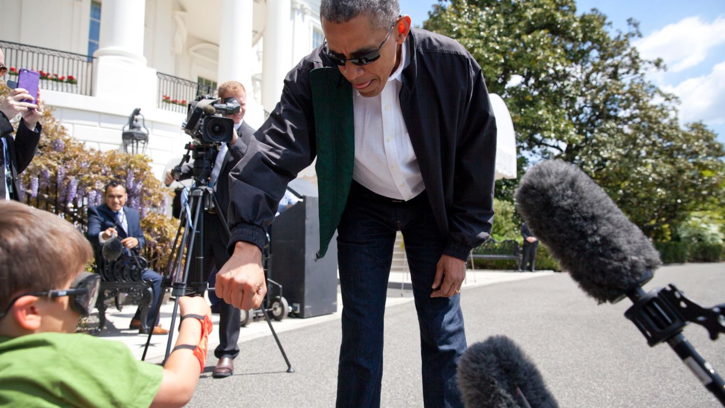 President Barack Obama greets Luca Martinez, 4, with a fist-bump as he walks from the White House to board Marine One.