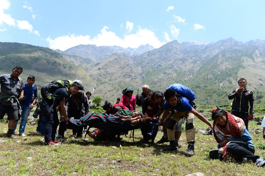 An injured Nepalese woman is carried by villagers toward an Indian army helicopter to be airlifted from Philim village in Gorkha district in Nepal on May 3.