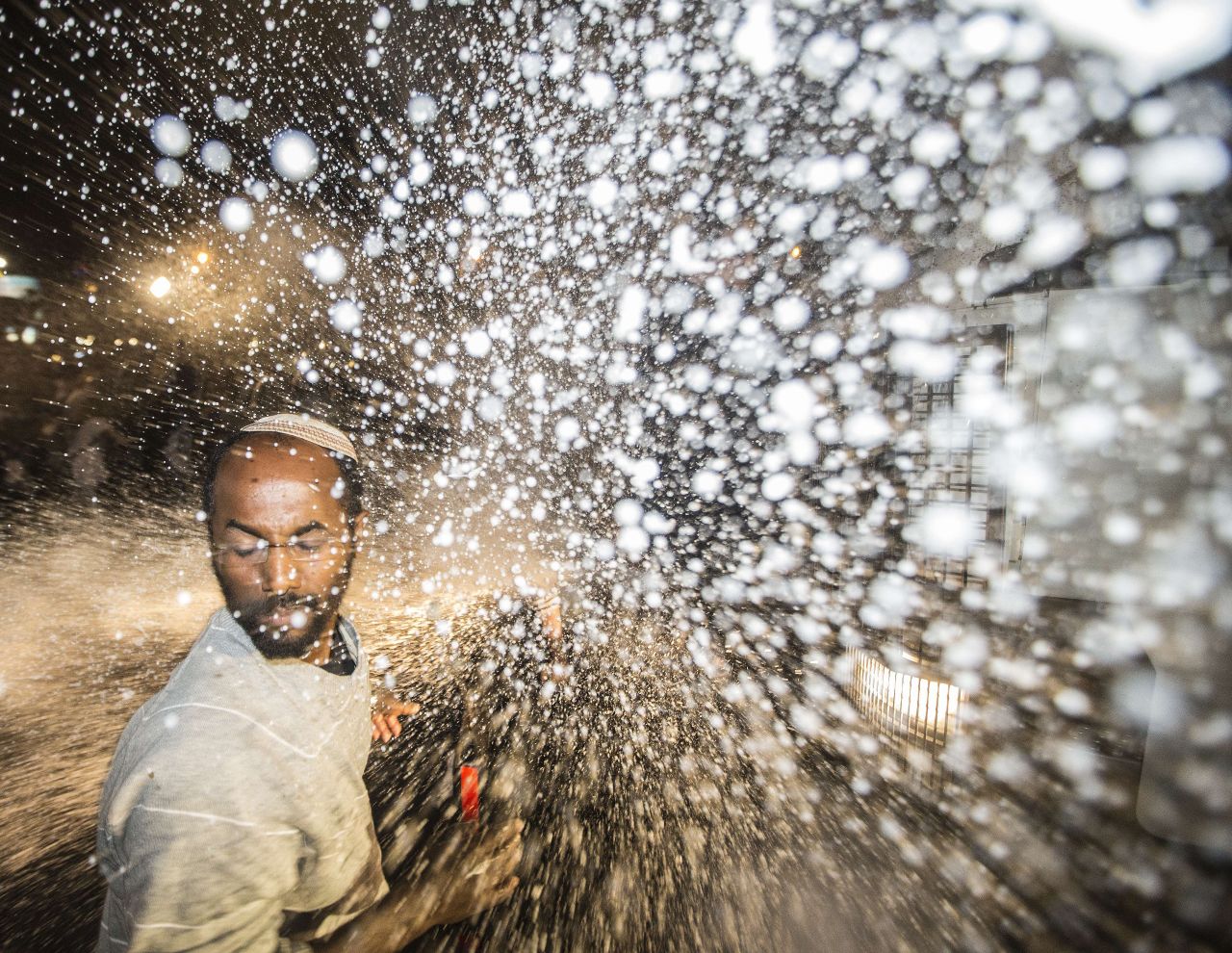A protester is hit by the spray from a water cannon. The Tel Aviv protest comes on the heels of a largely peaceful demonstration in Jerusalem on Thursday that drew more than 1,000 people. 