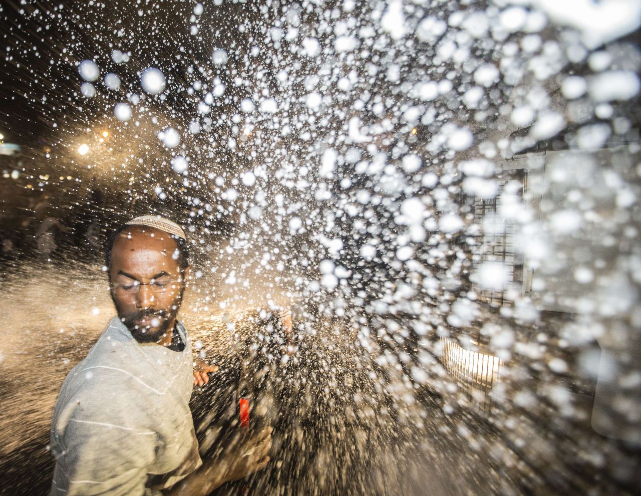 A protester is hit by the spray from a water cannon. The Tel Aviv protest comes on the heels of a largely peaceful demonstration in Jerusalem on Thursday that drew more than 1,000 people.
