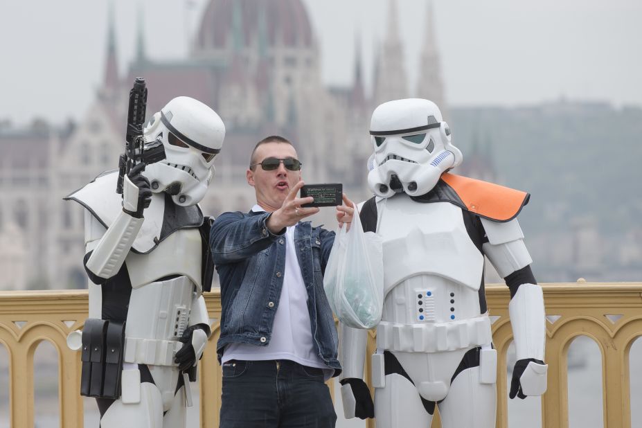A man takes a selfie with two "Star Wars" fans dressed as stormtroopers on May 3 in Budapest, Hungary.