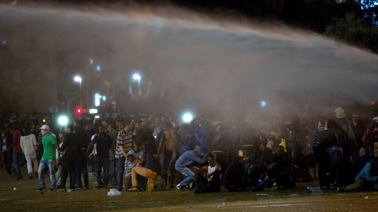 Protesters in Tel Aviv are hit by a water cannon as they clash with Israeli riot police during a protest against racism and police brutality on May 3.