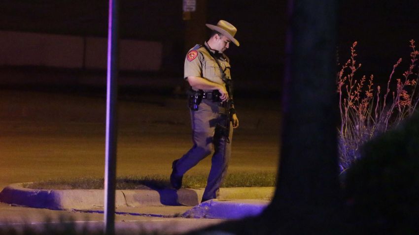 A Texas state trooper stands guard at a parking lot near the Curtis Culwell Center where a provocative contest for cartoon depictions of the Prophet Muhammad was held Sunday, May 3, 2015, in Garland, Texas. The contest was put on lockdown Sunday night and attendees were being evacuated after authorities reported a shooting outside the building. (AP Photo/LM Otero)