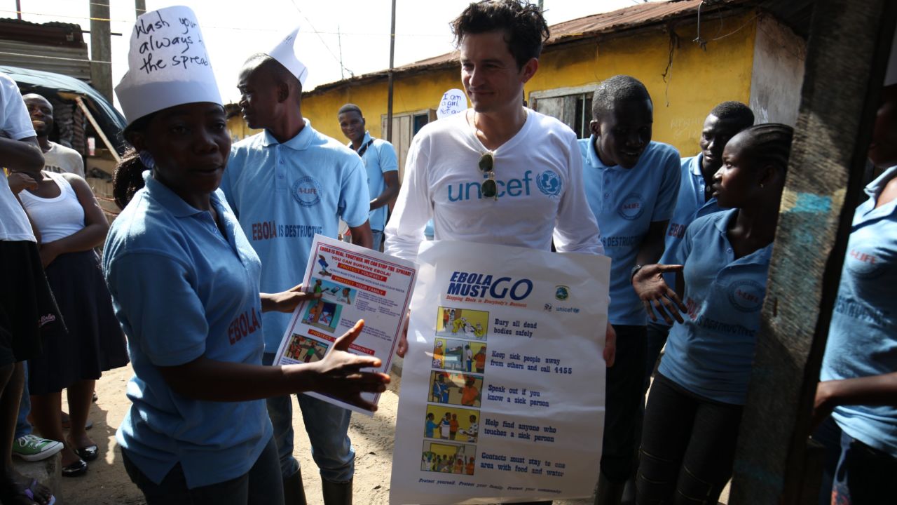 UNICEF Goodwill Ambassador Orlando Bloom carries posters about Ebola prevention, in Liberia.