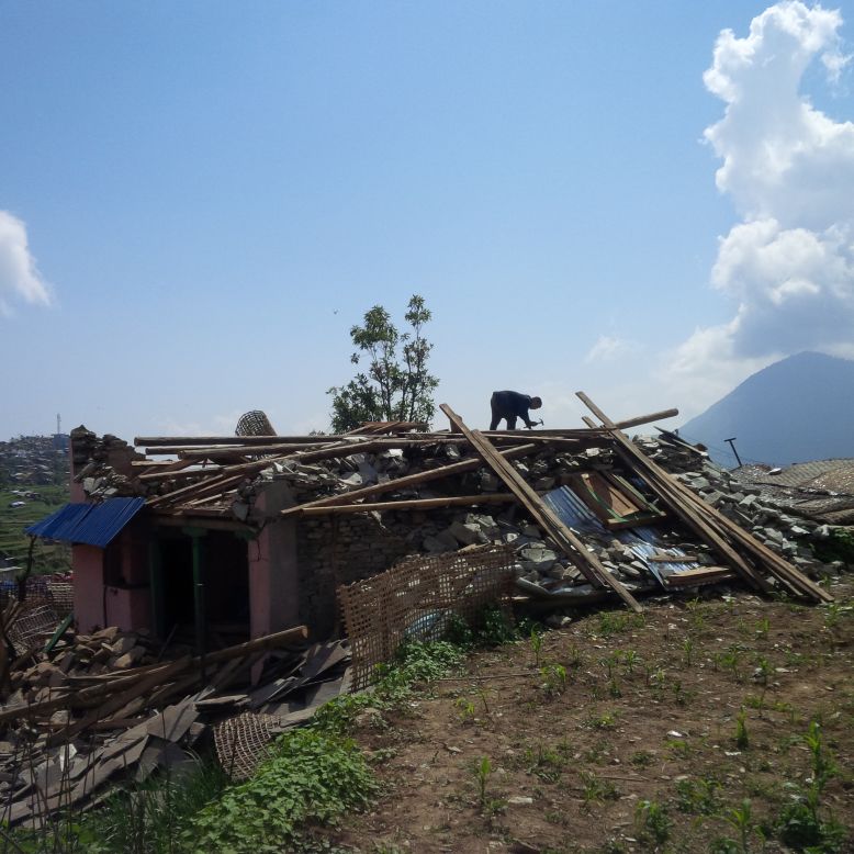 A man rebuilds his home in Barpak.