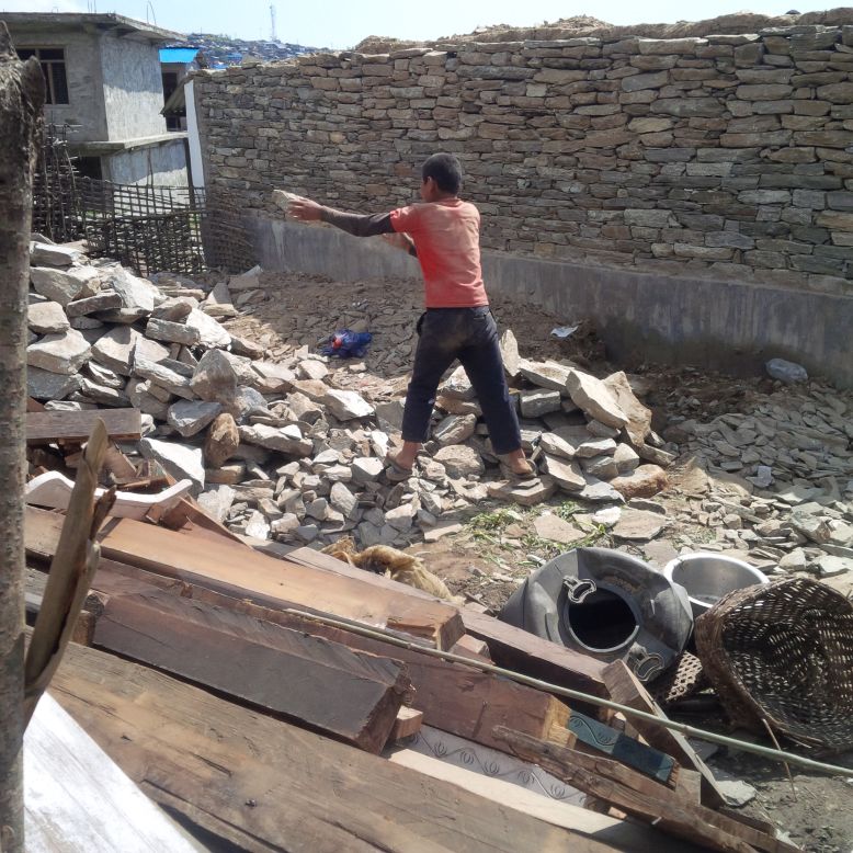 A boy from Barpak clears rubble. Here, at the earthquake's epicenter, aid has been frustratingly slow in arriving. 