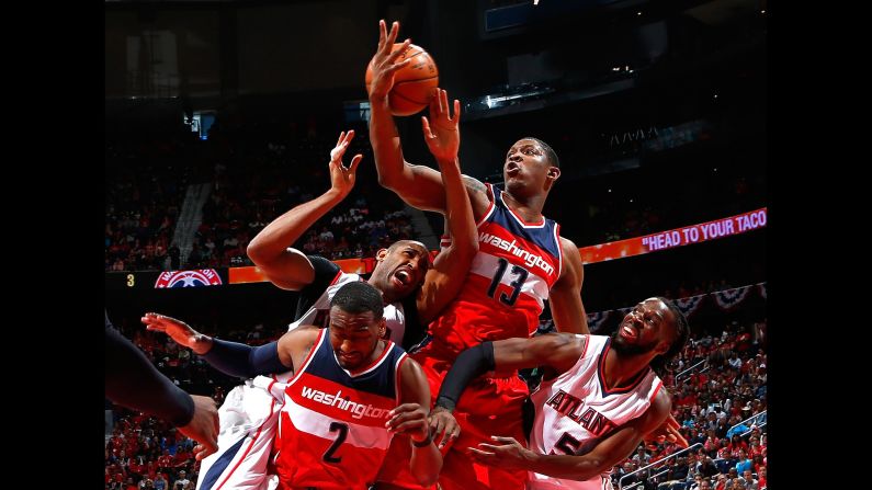 John Wall, lower left, and Kevin Seraphin, middle, of the Washington Wizards defend as Al Horford, left, of the Atlanta Hawks attempts a shot during the 2015 NBA Playoffs on Sunday, May 3, in Atlanta.