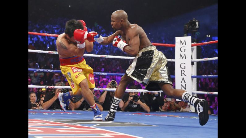 Manny Pacquiao covers his face as Floyd Mayweather Jr. punches during the first round in Las Vegas on Saturday, May 2.