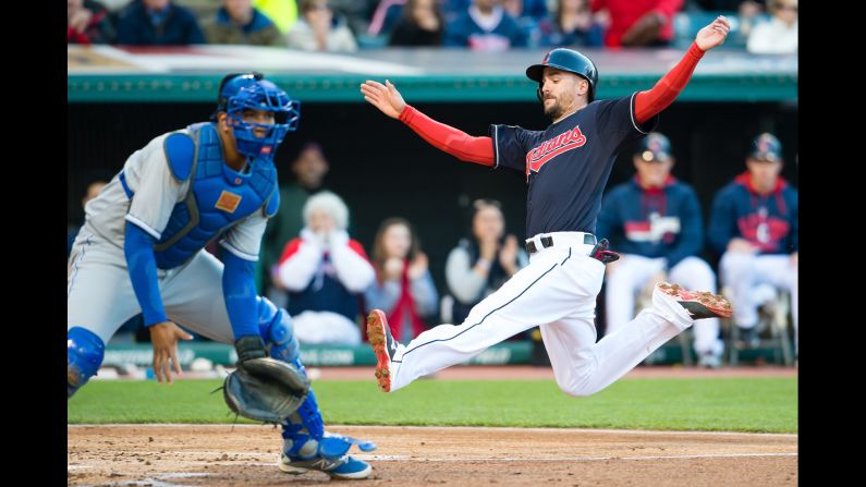 Kansas City Royals Catcher Salvador Perez waits for the throw as Cleveland Indians player Lonnie Chisenhall makes it safely to home plate on Tuesday, April 28, in Cleveland, Ohio.