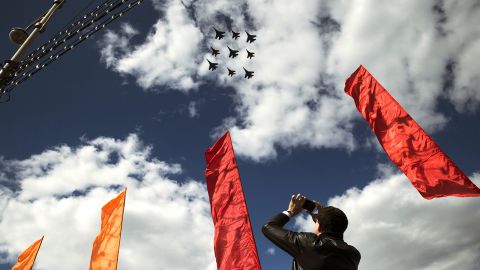 A man takes a picture of Russian Air Force fighter jets on Tuesday as they fly over Moscow during a rehearsal for the Victory Day military parade.