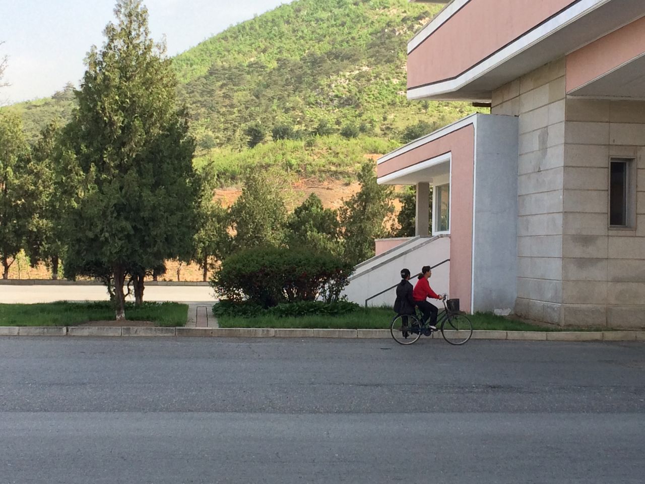 Two women share a bicycle as they head south on a highway leading from Pyongyang to the DMZ.