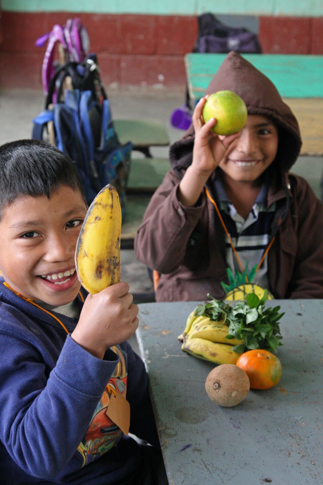 Students show off their "purchases" at a pretend market in school. The exercise encourages them to choose local fruits and vegetables over junk food.  