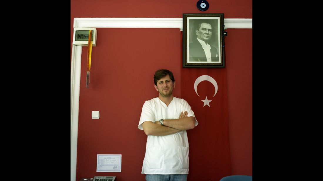 A nurse at a private clinic specializing in care for the elderly in Antalya poses beneath Ataturk's portrait. According to Emin, the whole reception room was painted a patriotic red. 