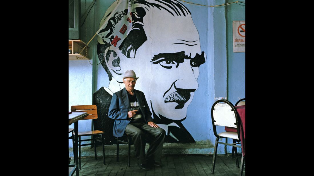 A customer in a coffee house in Tonya, near the Black Sea city of Trabzon, poses in front of a large mural of Ataturk.