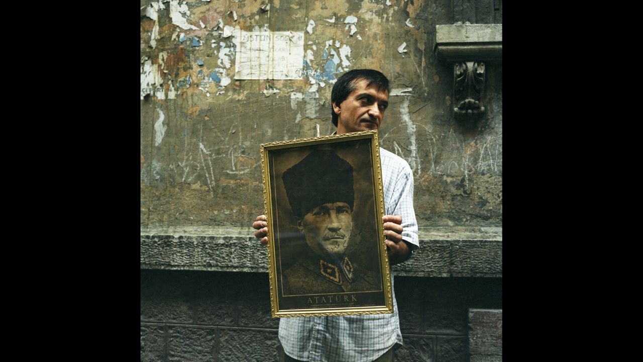 An antiques dealer on a back street in Istanbul's fashionable Beyoglu district holds an image of Ataturk for sale. "This is where I bought the framed Ataturk portrait that hangs in my home in London," said Emin.<br />