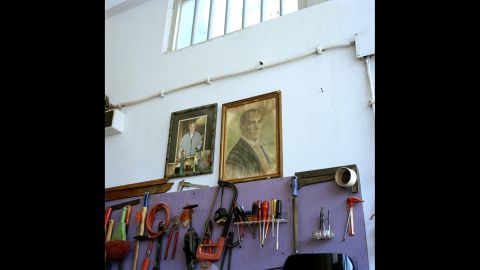 An image of Ataturk hangs alongside a photograph of a deceased family member in a backstreet garage in Istanbul.<br />